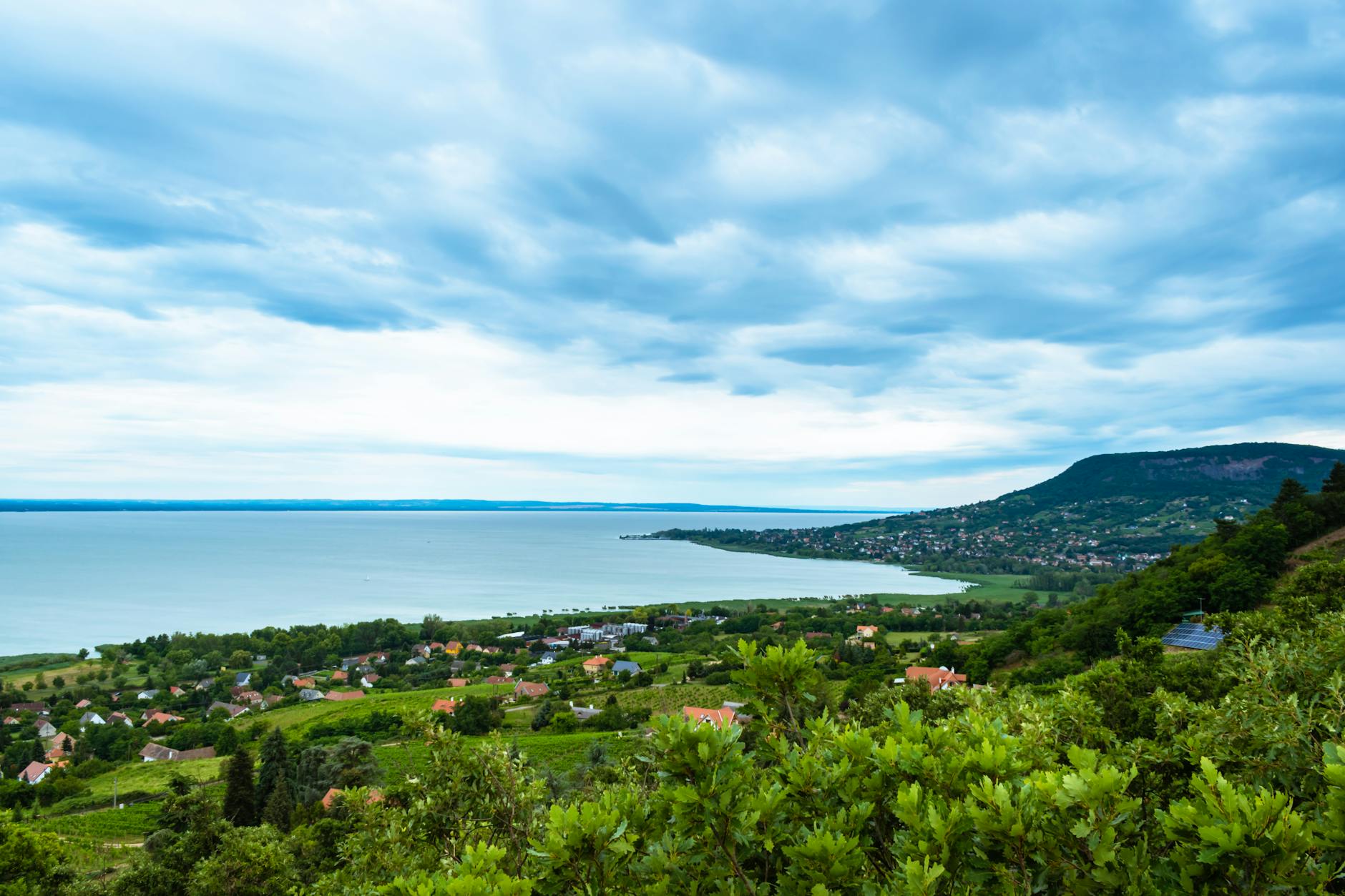 Panorama Badacsonytomaj i jeziora Balaton pod zachmurzonym niebem