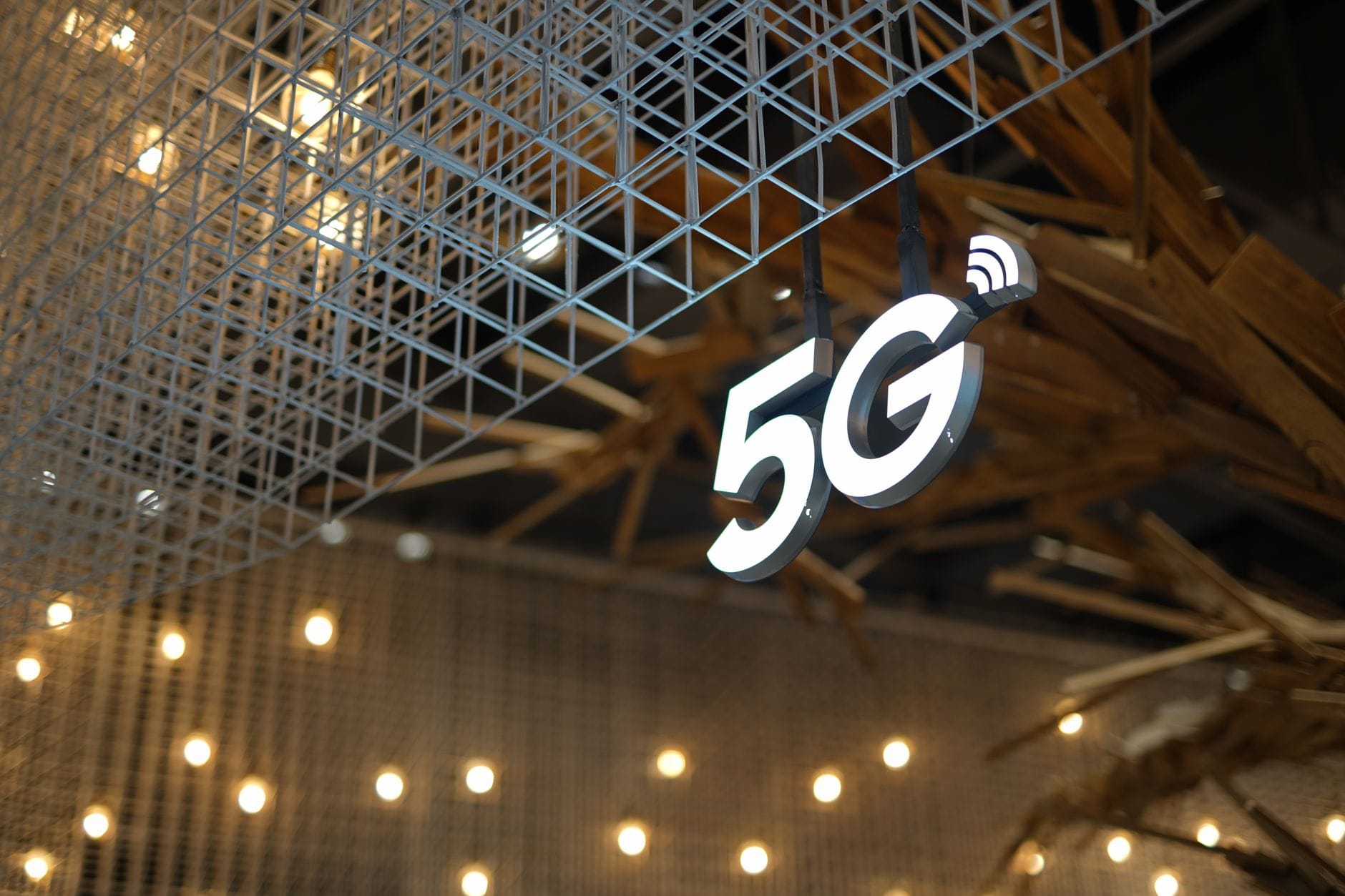 Podświetlony napis 5G na tle nowoczesnego, geometrycznego sufitu