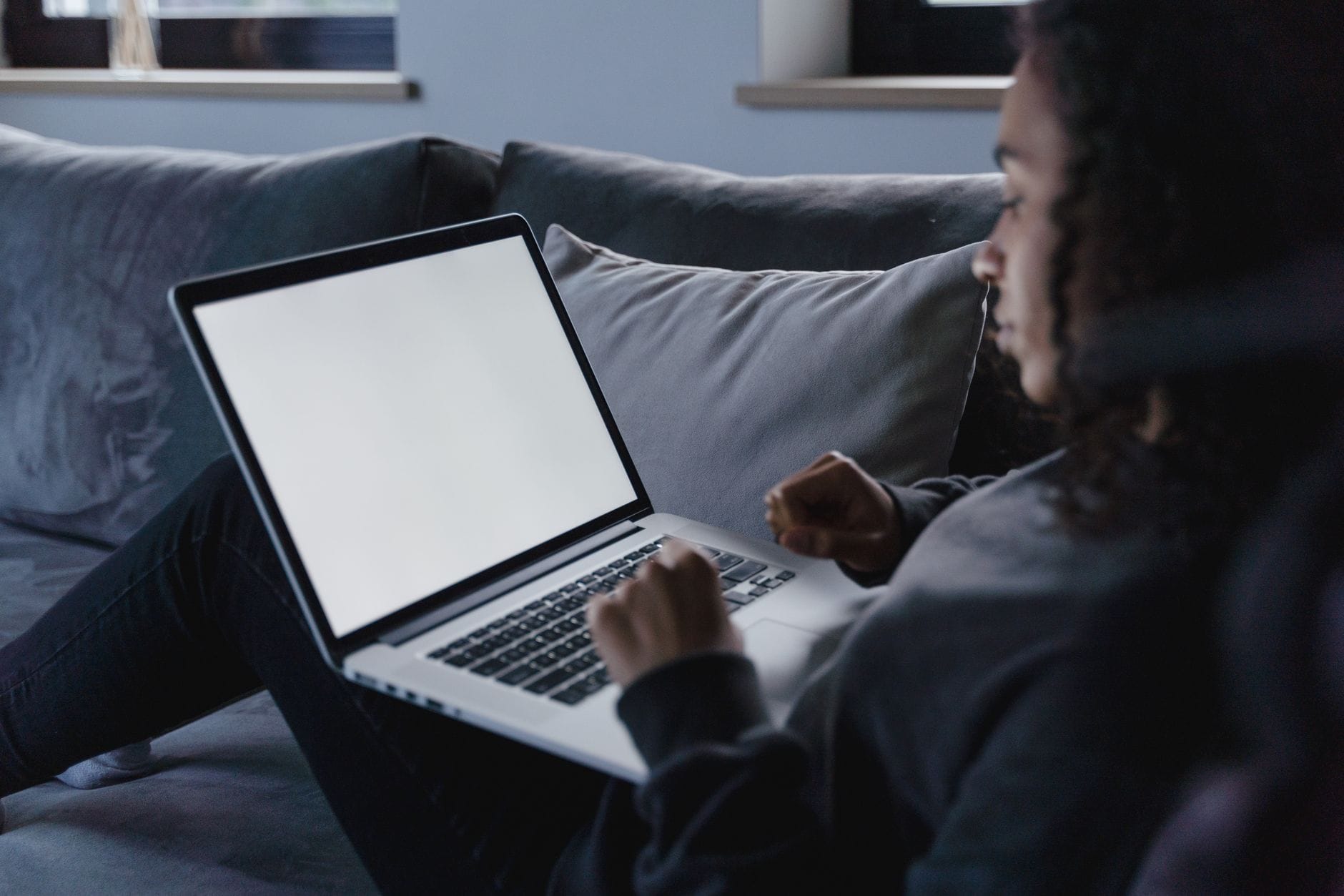 Młoda kobieta przy laptopie w przytulnym salonie
