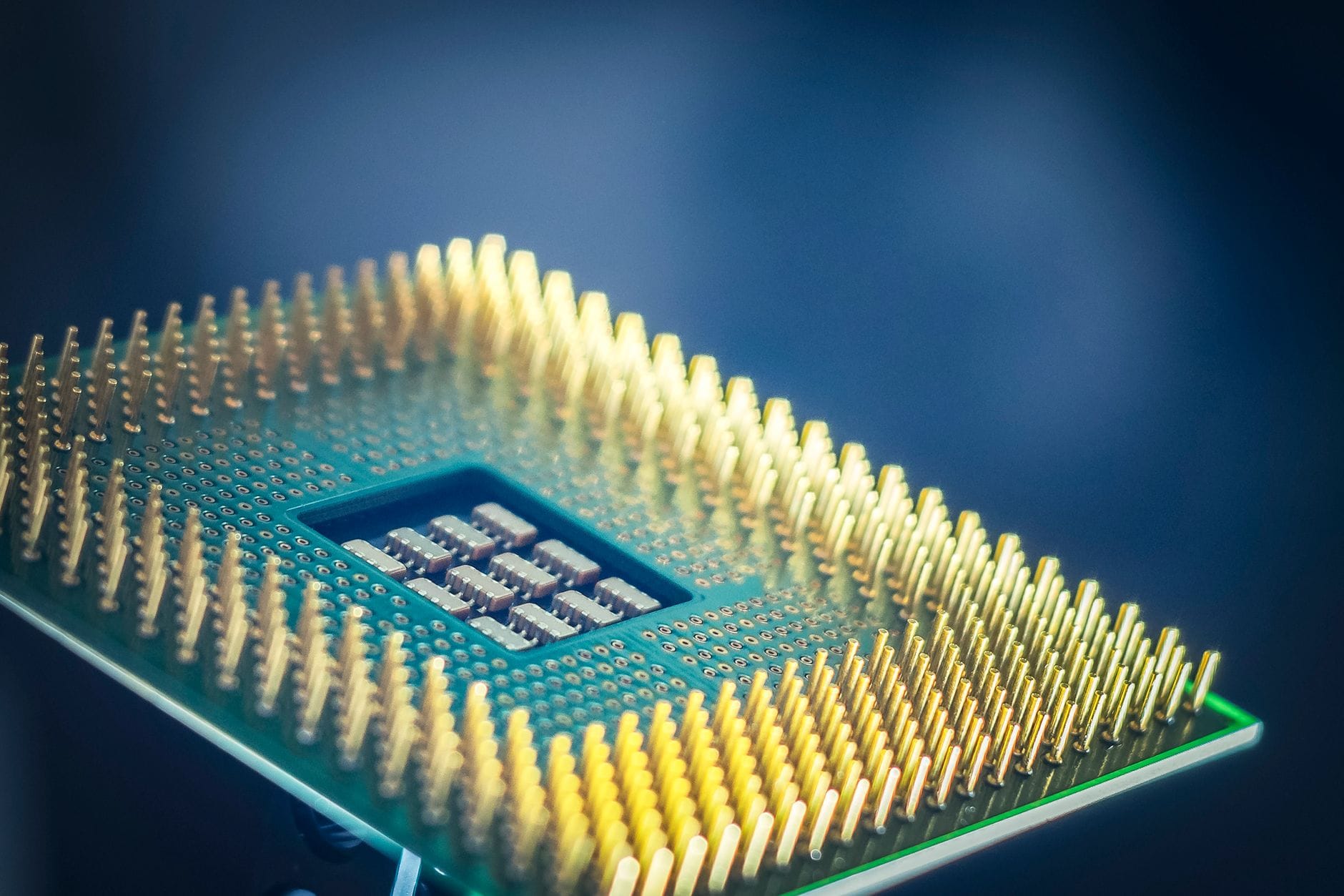 CPU, GPU czy TPU: który procesor wybrać do obliczeń AI pod kątem efektywności Zbliżenie procesora CPU z pozłacanymi pinami na niebieskim tle
