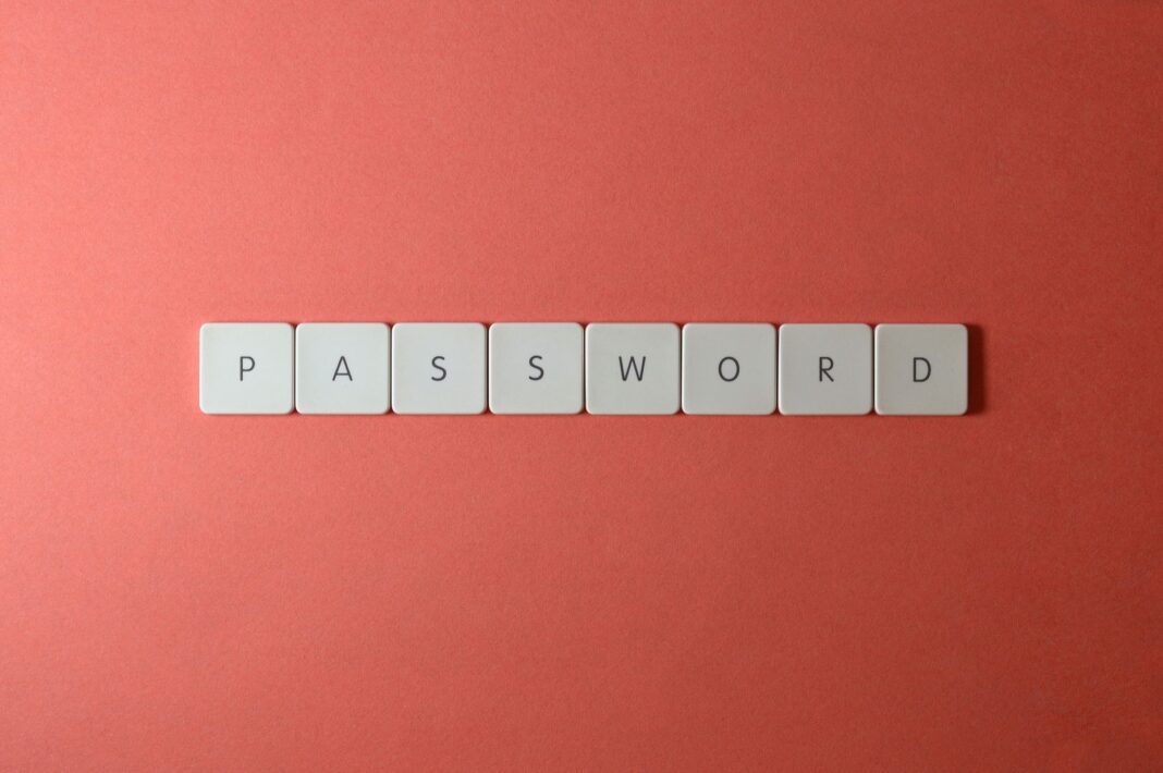 Białe klawisze układające słowo PASSWORD na koralowym tle