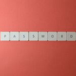 Białe klawisze układające słowo PASSWORD na koralowym tle