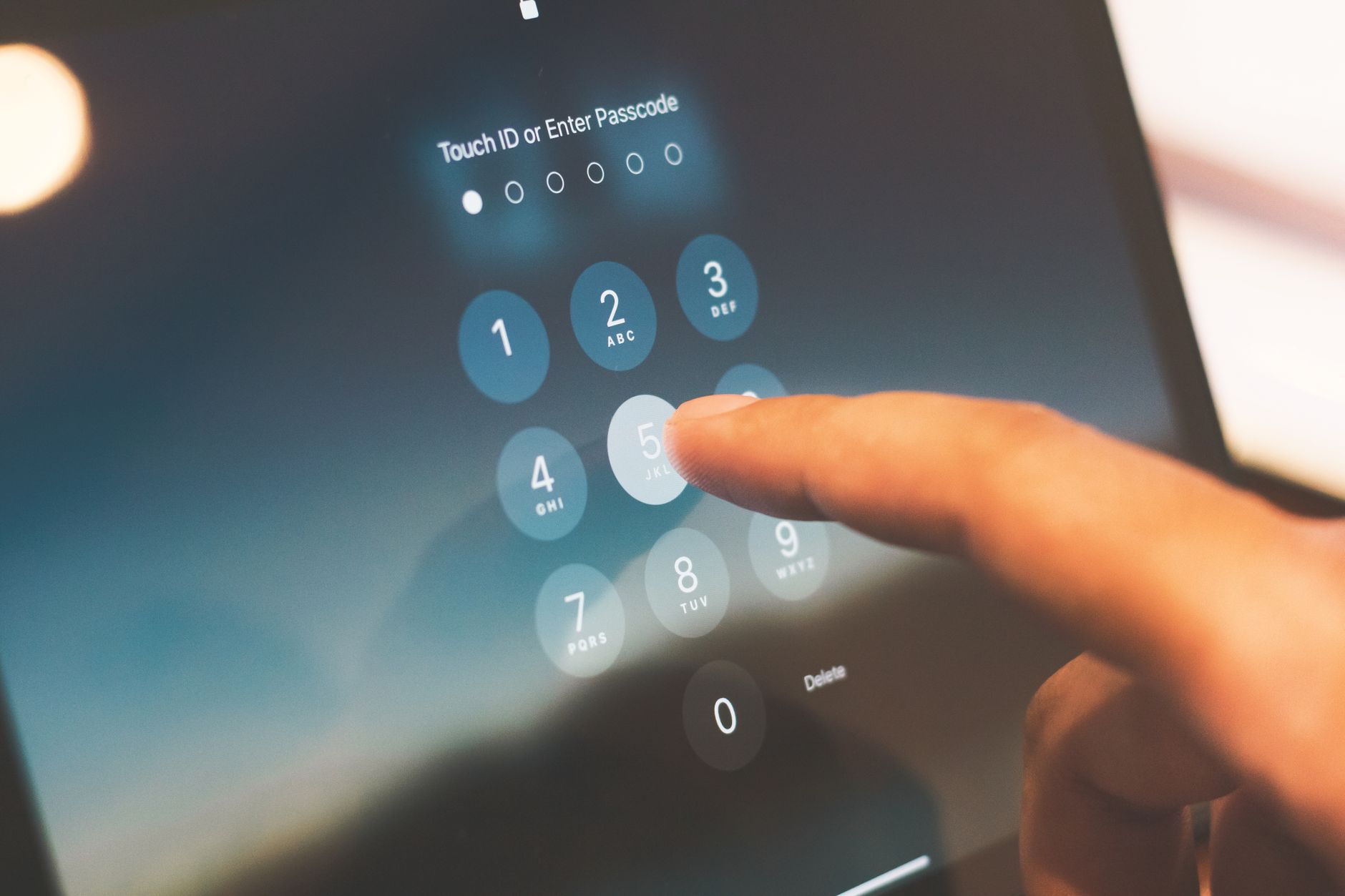 Palec wpisujący kod zabezpieczający na ekranie smartfona