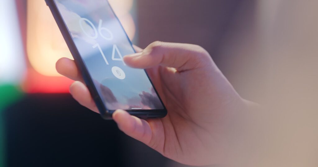 Dłoń trzymająca smartfon z blokadą odcisku palca
